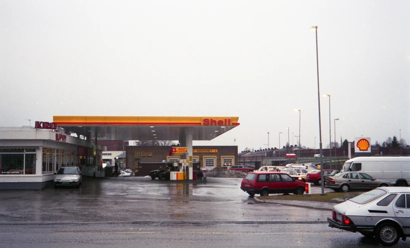 a gas station with a row of cars parked outside in front of it