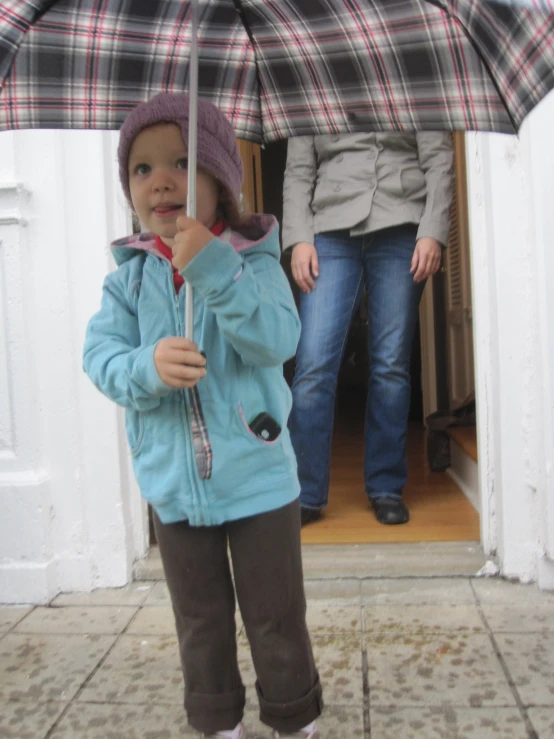 a child is standing outside under an umbrella