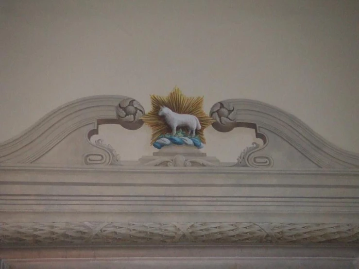 a white and gold statue of a dog on top of a mantle