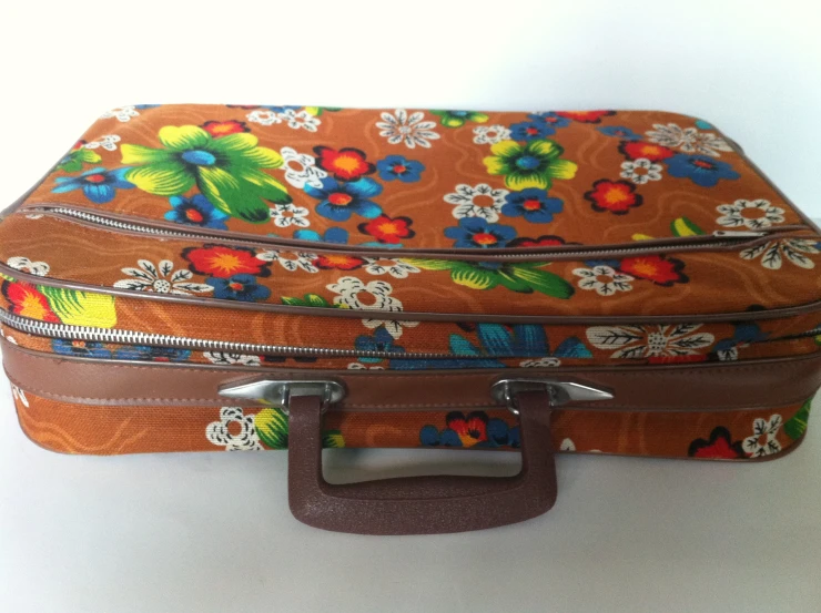 a brown suitcase with multicolored floral print