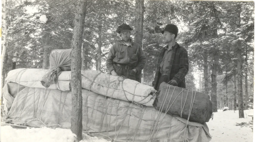 a couple of people standing in front of a bed in the snow