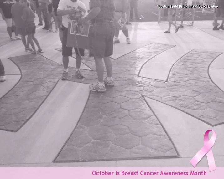 a woman wearing pink stands on the walkway that has pink awareness tape on it