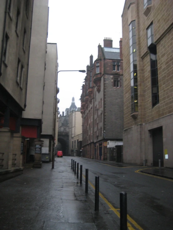 a quiet and narrow street with buildings along the sides