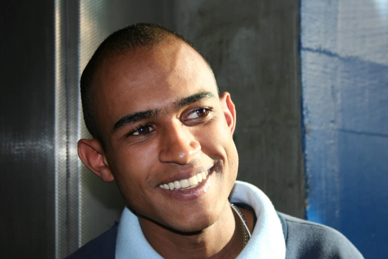 an african american man smiles in front of the camera