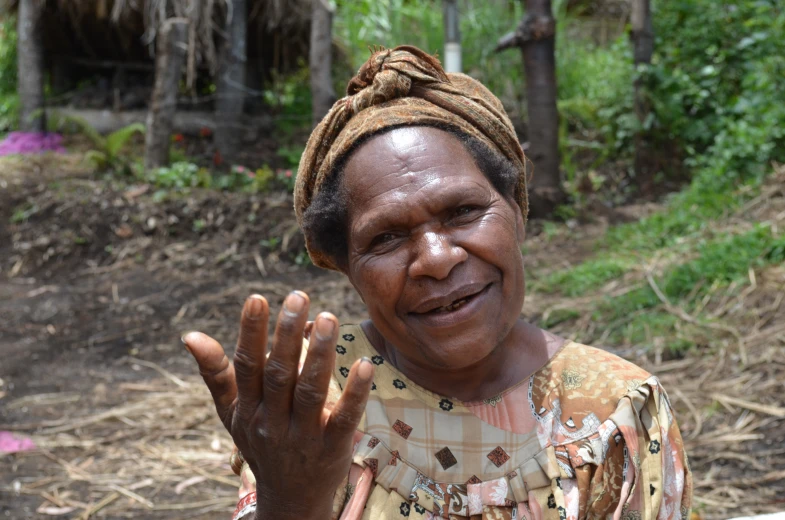 a woman standing in a dirt area with her hands up and her eyes open