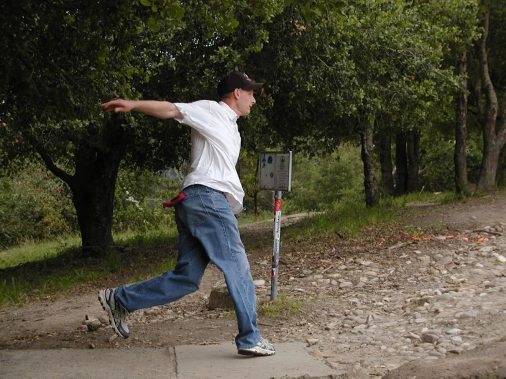 a man throwing a frisbee on top of a sidewalk