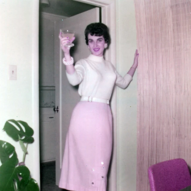 an old po of a woman holding a glass of wine