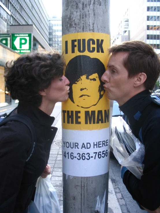 a poster advertises men as if to kiss each other