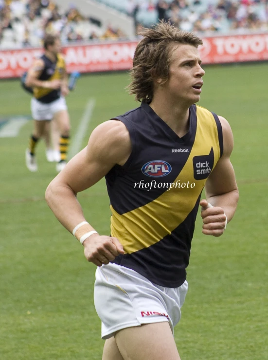 the man in yellow and black is running through the field