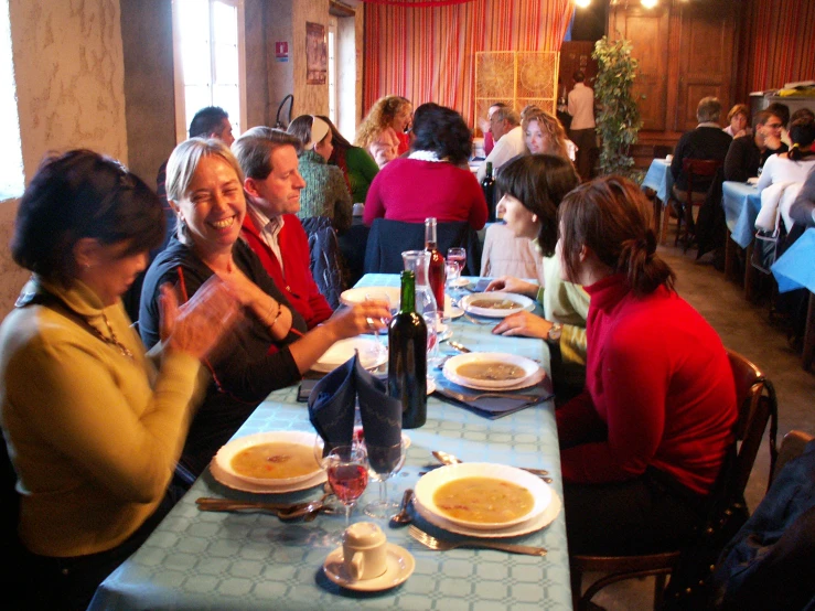 people sitting around tables at a restaurant eating