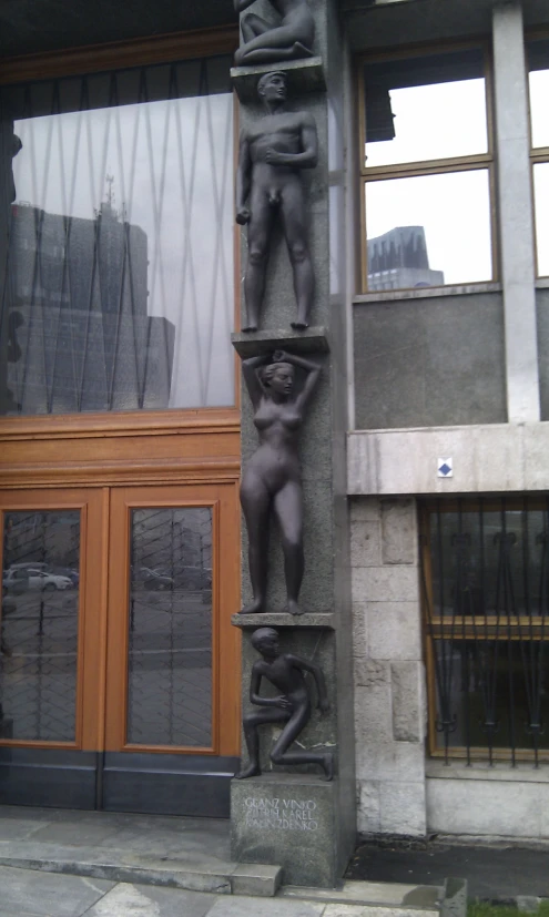 a sculpture on the side of a building that has a door in it