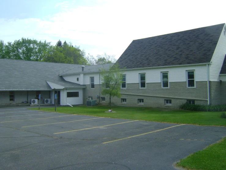 a large gray building sitting next to a lush green forest