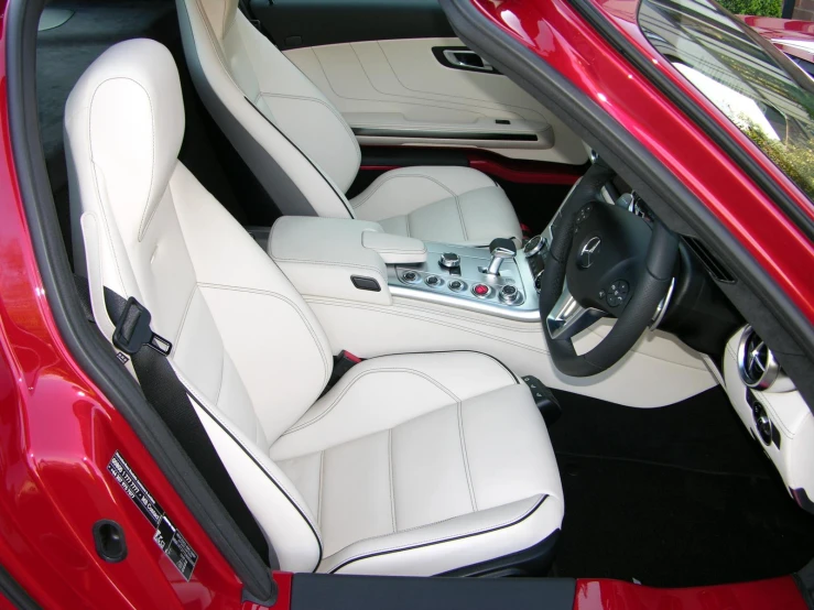 the interior of a red sports car with its steering wheel down