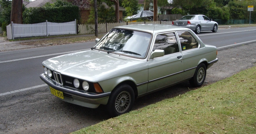 a light green car parked on the side of a street