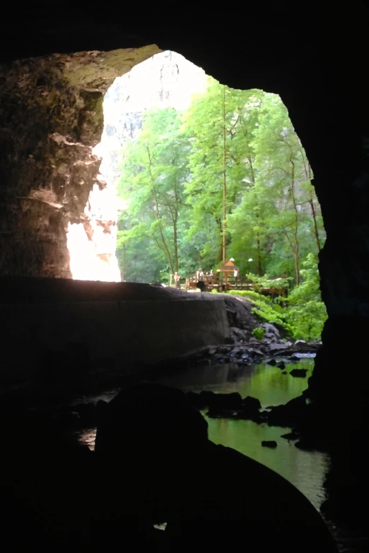 light entering a cave with a person standing in the entrance