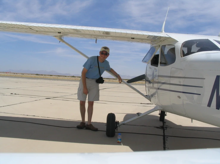 a man standing next to a small propeller plane