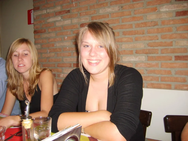 two women sitting at a table smiling for the camera