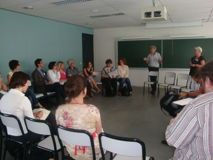 a man in a white shirt talking to a class