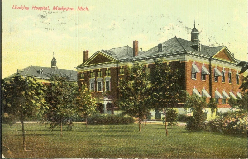 an old - fashioned po of a large building on a grass field