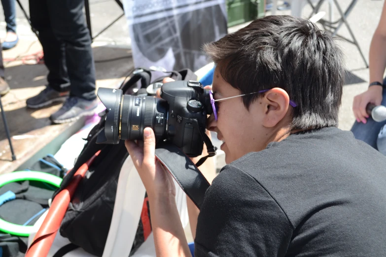 a boy looking at soing while using a camera