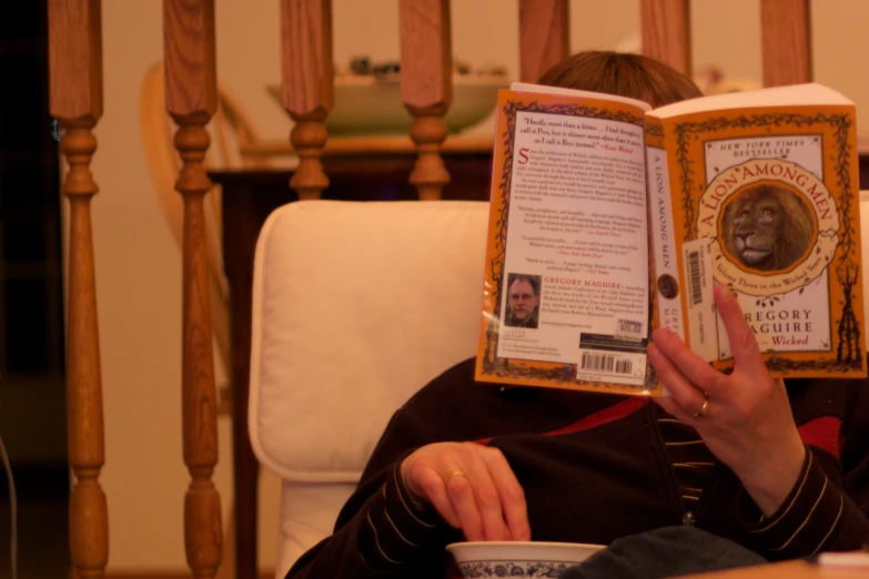 the woman is reading a book with an orange cover