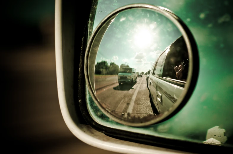 a side mirror showing a view of a highway