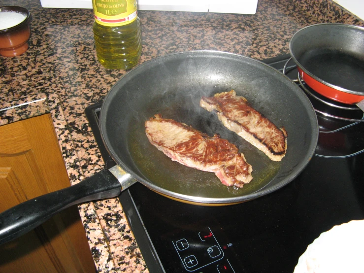 meat cooking on the stove in a frying pan