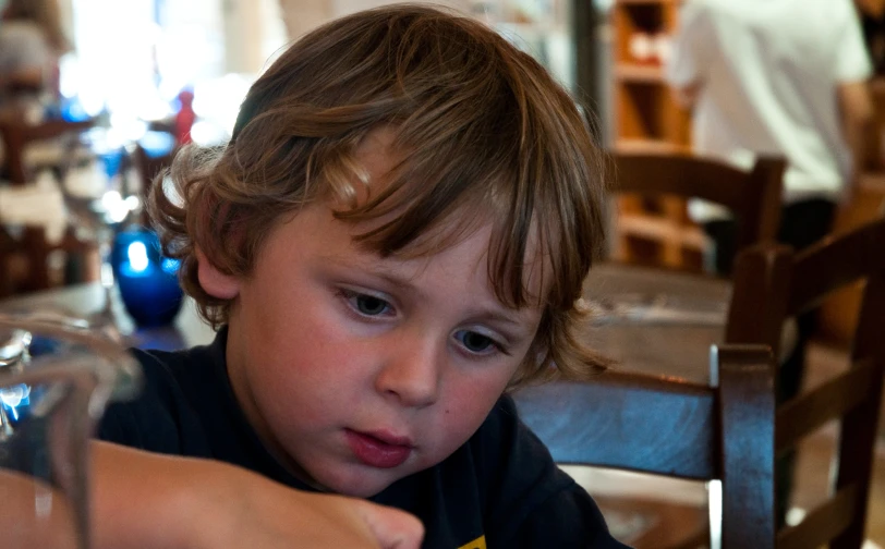 the little boy is sitting at the table