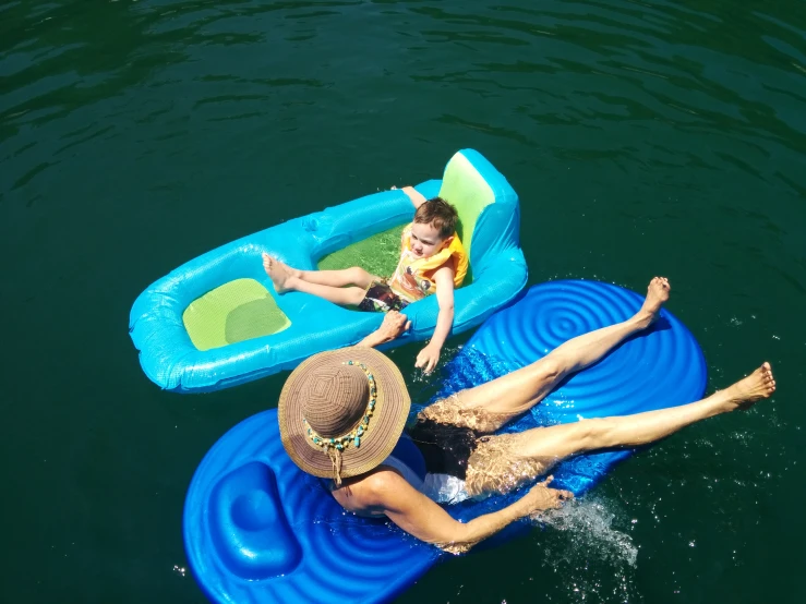 two people floating on inflatable rafts with a swimming ring