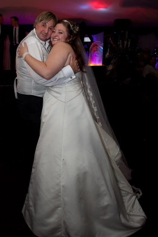 a bride and groom dancing at a party