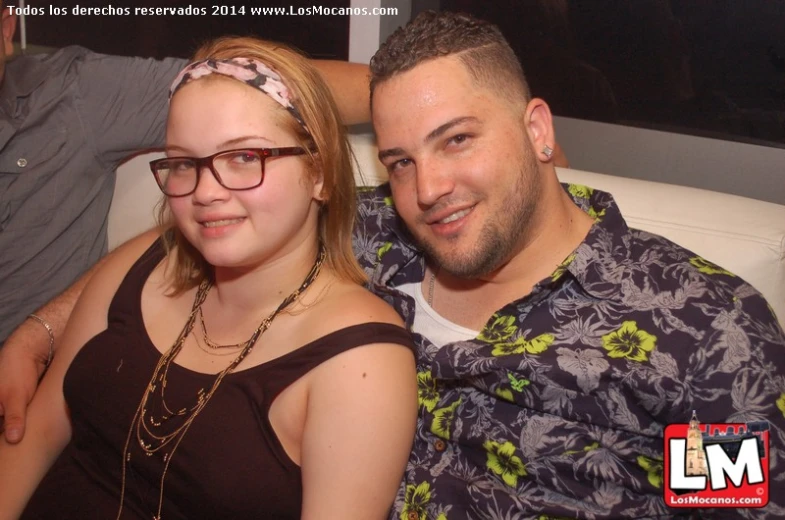 a man and woman pose for a picture while they have their arm around each other