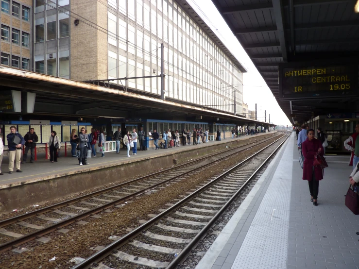 some people are standing at the train station