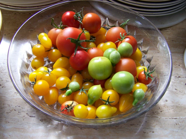 a glass bowl filled with a bunch of tomatoes