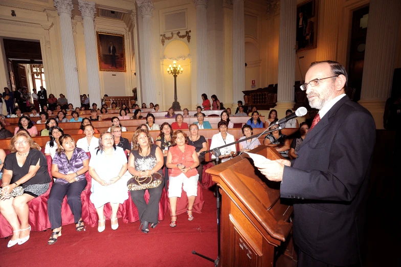 a man standing in front of a microphone at a podium