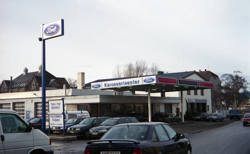 a gas station with several cars and trucks parked