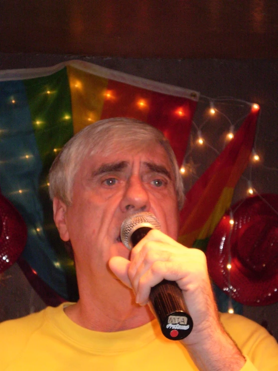 a man with a microphone in front of colorful lighting