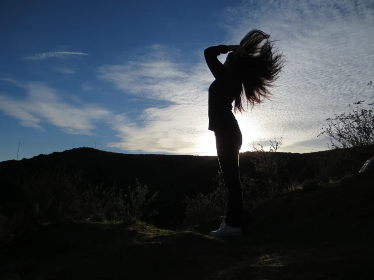 woman is holding her hair up standing outside