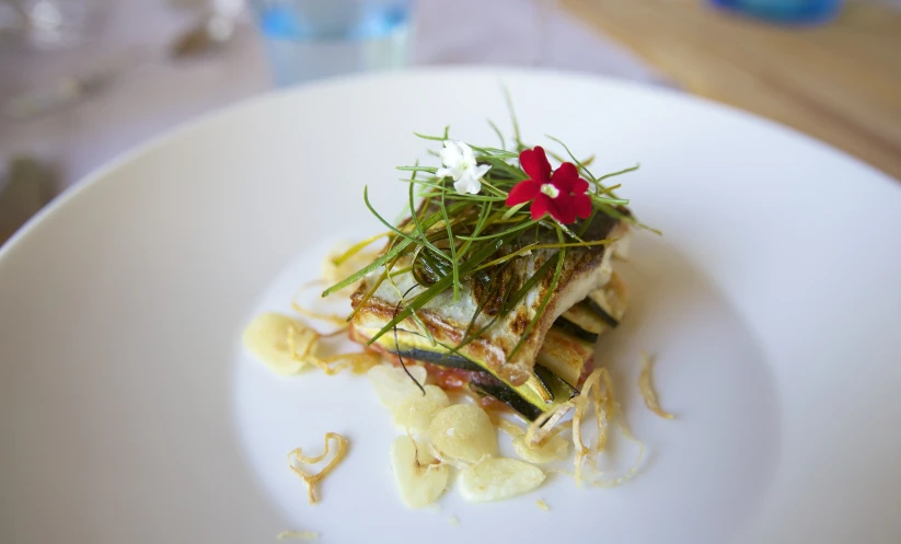 a square plate of food with many flowers on top