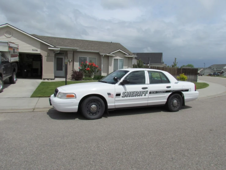 the police car is parked next to a suburban home