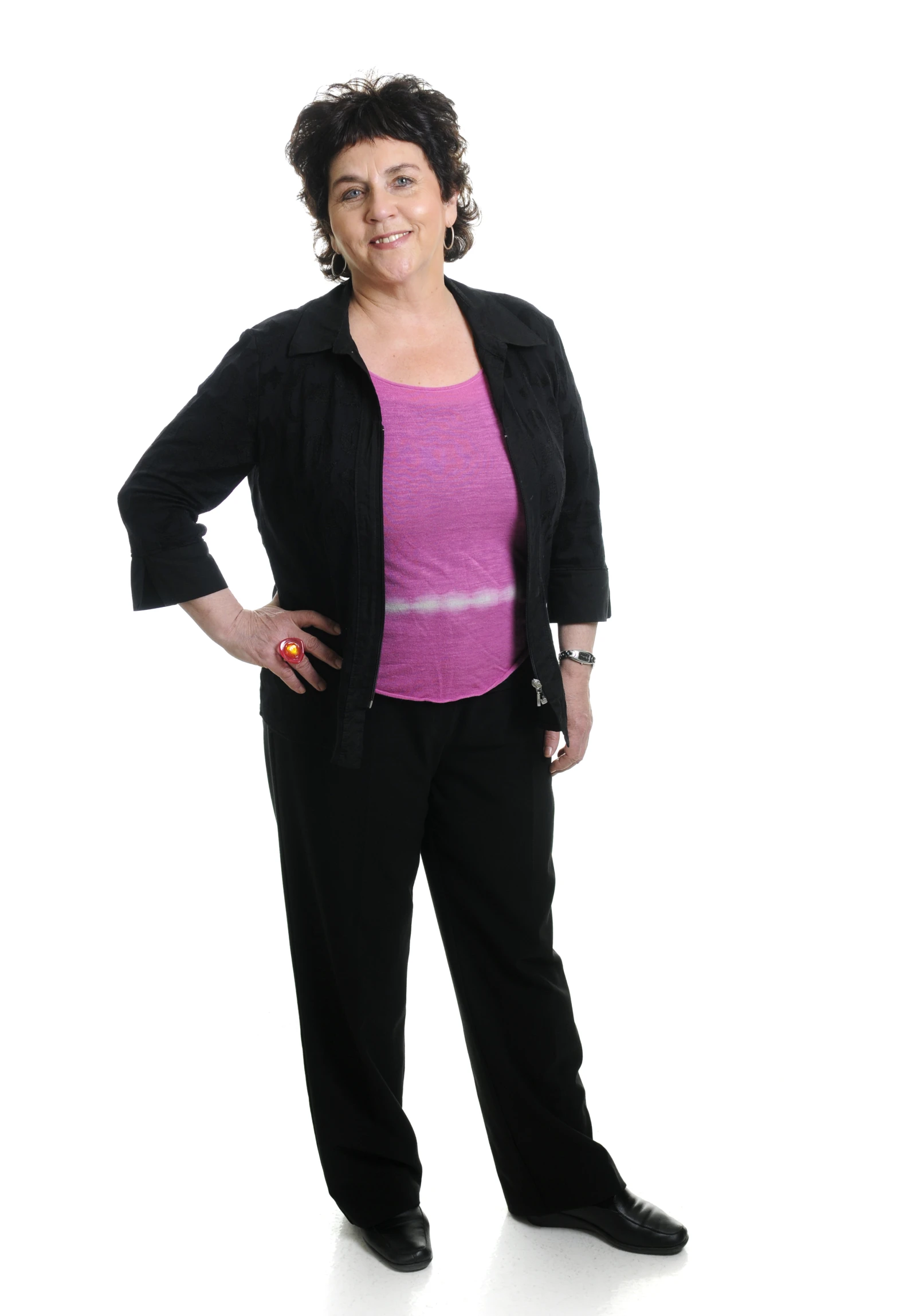 a woman standing wearing a pink shirt and black pants