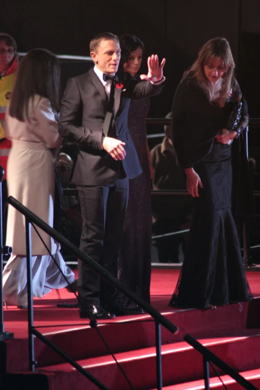 a man and woman standing on some stairs waving