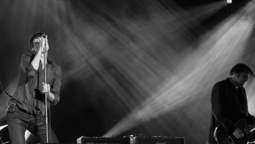 a man holding onto a string as he sings on stage