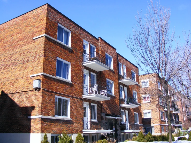 apartment complex with large windows and brown brick facade