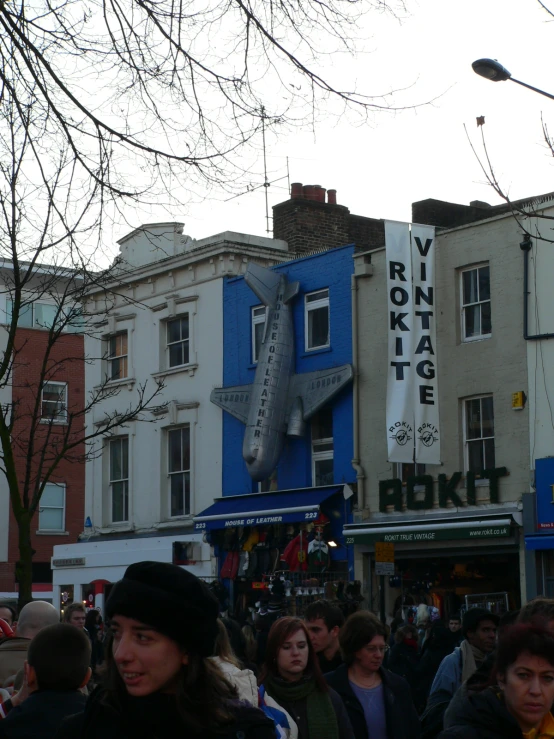 a crowd of people standing next to some stores