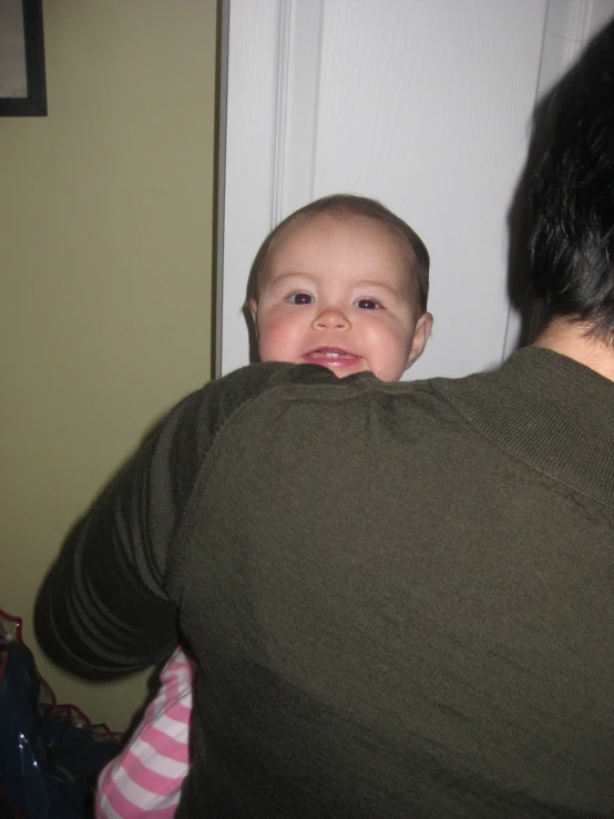 a baby standing in front of a door with it's parent