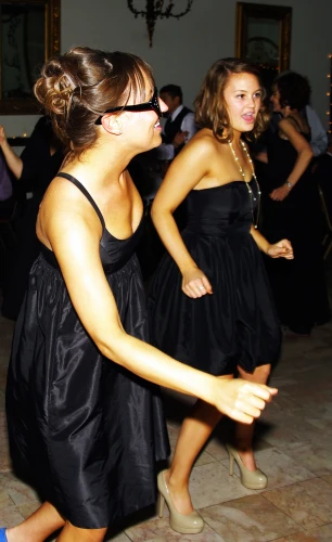 a couple of women walking around a dance floor
