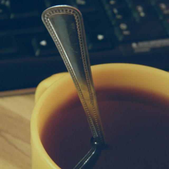the cup of tea has a metal scoop and metal spoon