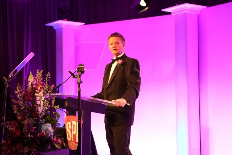 a man is making a speech at a podium