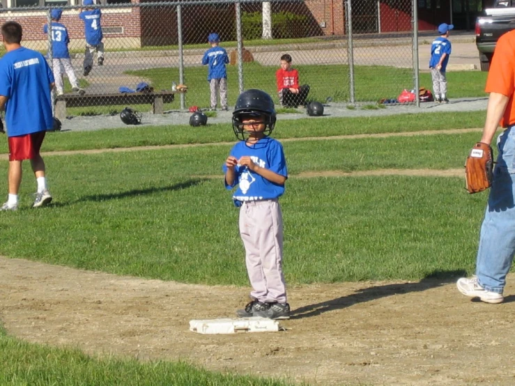 a  in a blue baseball shirt standing in a field