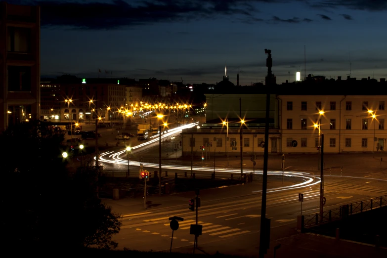 a dark city at night, with a line of streetlights